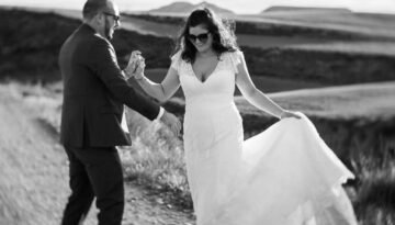 Couple de mariés dansant et riant dans le désert des Bardenas, photo noir et blanc contrastée