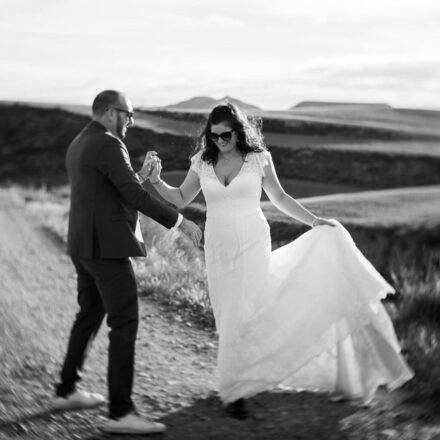 Couple de mariés dansant et riant dans le désert des Bardenas, photo noir et blanc contrastée